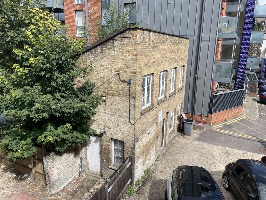 Lot: 113 - VACANT TWO STOREY BUILDING - Outside image of building taking from adjacent flat fire escape staircase, overlooking building